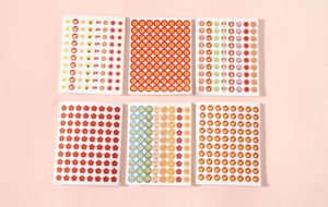 Close-up of 6 sheets of colorful reward stickers for students featuring stars and flowers