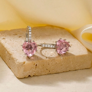 Dettaglio di orecchini a cuore rosa con cristalli, metallo argentato e piccoli diamanti