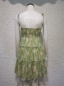 Detail of green floral dress back featuring elastic smocked bodice and tiered ruffle skirt