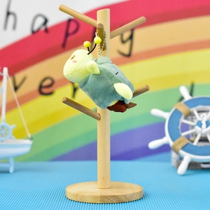 Close-up van een schattige pluche schildpad sleutelhanger met bijenantennes aan een houten standaard