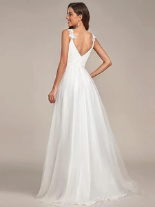 Detail view of deep V-neck backless wedding dress with floral lace straps and tulle skirt