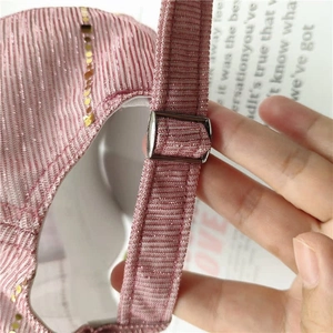 Detail of adjustable metal buckle and pink glitter fabric on a stylish baseball cap