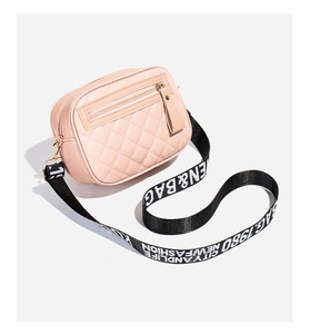 Close-up of pink quilted crossbody bag with stylish black logo patterned wide strap
