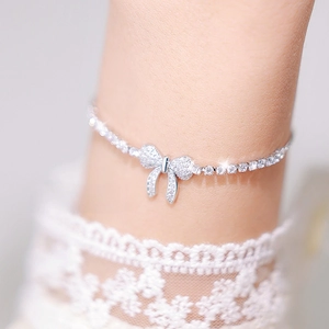 Macro view of silver bow bracelet with micro-pave zircons and delicate link chain