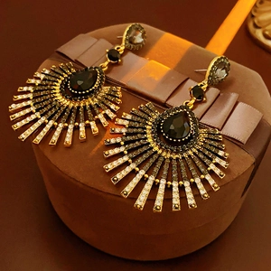 Detail of vintage fan-shaped tassel earrings with black stones on a gift box