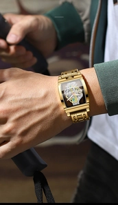 Close-up of golden tonneau skeleton watch showing mechanical gears and luminous dial