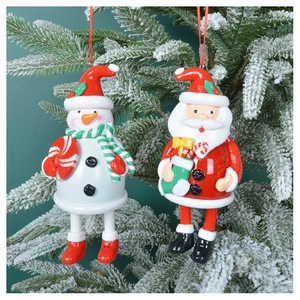 Detailed view of 3D Santa and snowman resin ornaments hanging on a snowy Christmas tree