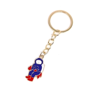 Close-up of a colorful enamel astronaut keychain with golden metal ring and chain link