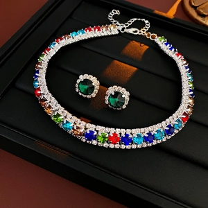 Detailed view of luxury silver necklace and green earrings with colorful rhinestones