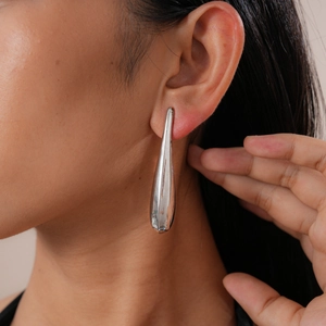Close-up of polished silver teardrop earrings worn by a model for a stylish look