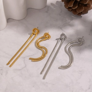 Boucles d'oreilles élégantes à longs glands en chaîne serpent or et argent sur marbre