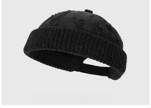 Close-up of black distressed knit beanie showing vintage ripped texture and ribbed edge