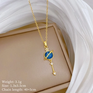 Detailed close-up of golden galaxy planet pendant with blue stone on a display box