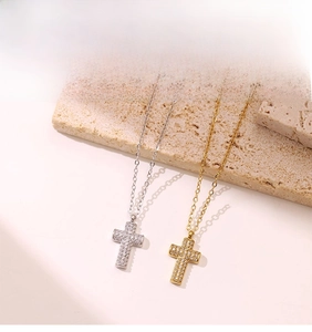 Detailed view of gold and silver cross necklaces with micro-paved zircons on stone