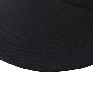Detailed close-up of double stitching on black military hat brim with metal stud accents