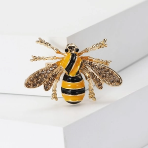 Detailed view of bee brooch featuring yellow enamel stripes and sparkling rhinestones