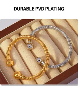 Detail of gold and silver twisted cable open bangles with PVD electroplated finish