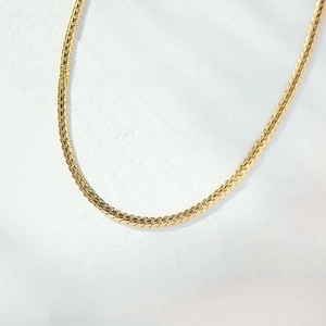 Detail of 18K gold plated flat snake chain necklace showing fine herringbone texture