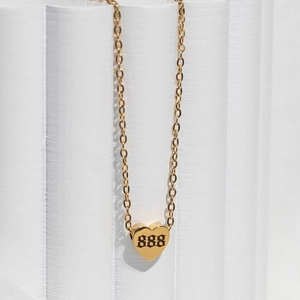 Detailed view of gold heart pendant featuring gothic number 888 on a classic cross chain