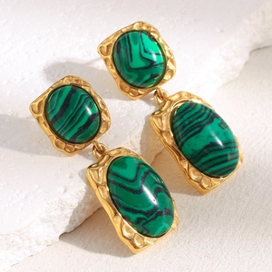 Détail de boucles d'oreilles en acier doré 18 carats avec incrustations de malachite
