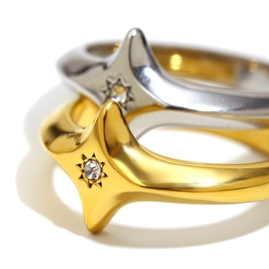 Macro shot of 18K gold and silver starburst rings featuring a sparkling center zircon