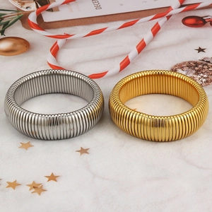 Polished gold and silver snake bone stretch bracelets on a festive marble background