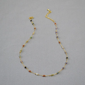 Detail of beaded gold chain necklace featuring colorful micro-cut natural stones and clasp
