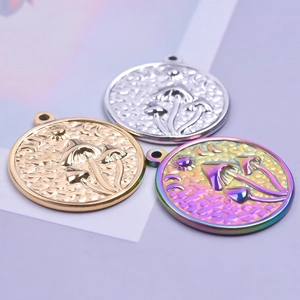 Macro view of mushroom and moon embossed stainless steel pendants in gold silver and rainbow