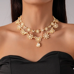 Detail of vintage gold-tone double-layer necklace with floral motifs and waterdrop crystals
