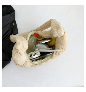 Macro view showing large capacity of the beige pleated cloud bag with daily essentials