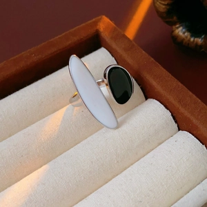 Detail of silver oval open ring with black and white enamel in a linen jewelry box