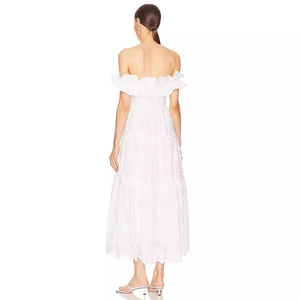 Elegant white off-shoulder maxi dress with ruffled slit and detailed hollow embroidery