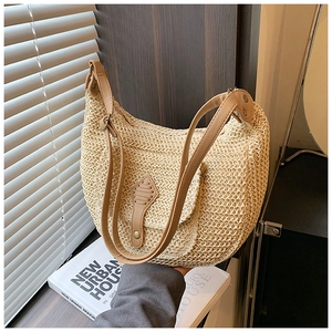 Beige woven crescent shoulder bag with brown leather straps for beach holidays