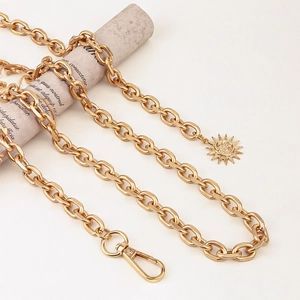 Detailed view of gold punk style waist chain with sun pendant and lobster clasp