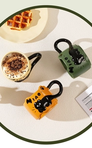 Top view of creative ceramic mugs with cute black cat handles in yellow and green