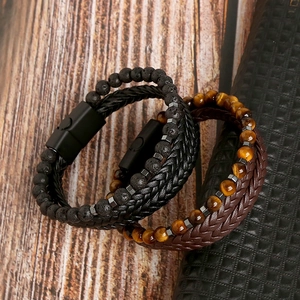 Dettaglio di bracciali da uomo in occhio di tigre e pietra lavica con chiusura magnetica