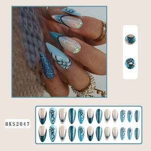 Detail view of teal glitter and floral almond press-on nails with shiny rhinestones