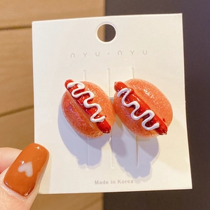 Detailed close-up of realistic hot dog shaped stud earrings on a display card