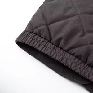 Detail view of black diamond quilted jacket cuffs showing stitching and texture