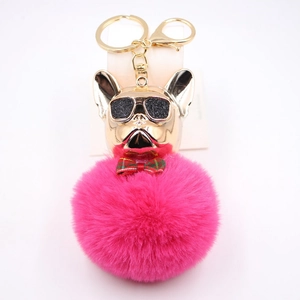 Dettaglio portachiavi bulldog francese con testa dorata e pompon di peluche color fucsia