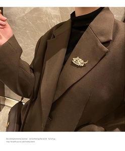 Elegant opal wheat stalk brooch with rhinestones pinned on a brown blazer lapel