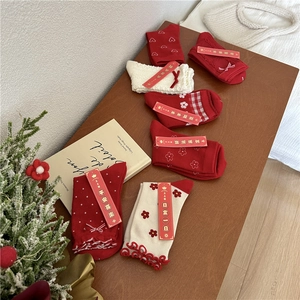 Detail of six pairs festive red and white cotton socks with embroidery and gift packaging