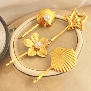 Golden alloy hair clip set featuring shell, star and pearl designs on satin background