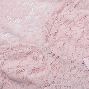 Close-up of pink lace fabric showing intricate floral patterns and sheer texture detail