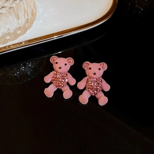Macro shot of pink flocked bear earrings with sparkling rhinestone heart and ears