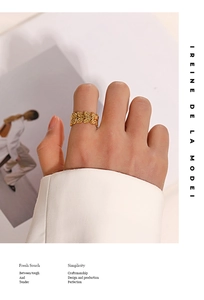Detailed view of adjustable gold leaf ring with intricate textures on the finger