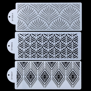 Three white plastic baking stencils with geometric patterns on a black background