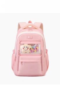 Detail of pink nylon school bag featuring a clear PVC pocket with plush stars and toys