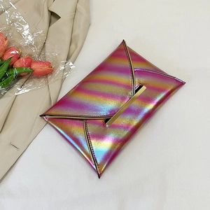 Rainbow gradient envelope clutch with gold metal bar closure on chic beige coat background