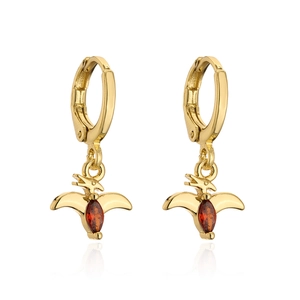 Detail of 18K gold dinosaur earrings featuring red cubic zirconia stones on white background